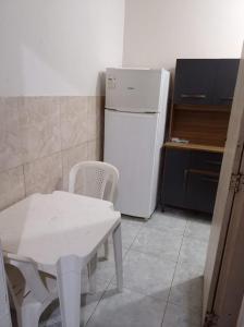 cocina con mesa blanca y nevera blanca en Residencial Barbosa - Apto 102, en Macaé