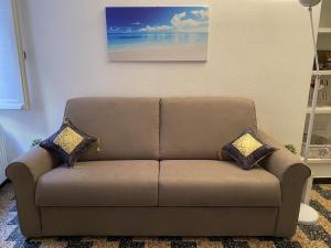 a brown couch with two pillows in a living room at Casa Dante - Lavagna in Lavagna