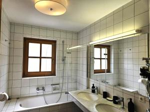 ein Badezimmer mit zwei Waschbecken und einer Badewanne und zwei Fenstern in der Unterkunft Deluxe Panorama Apartment-Maibrunn-Alm in Bad Kleinkirchheim