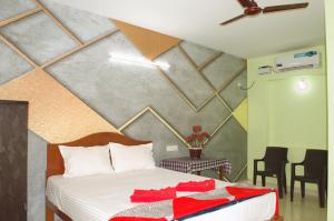 Un dormitorio con una cama con elementos rojos. en Flavia Paradise Guest House, en Canacona