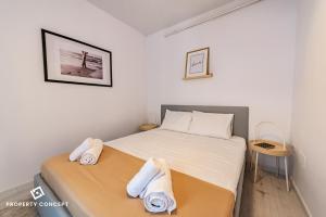 ein Schlafzimmer mit einem Bett mit Handtüchern darauf in der Unterkunft Central Residence Apartment 928 in Vatra Mînăstirii Cotroceni