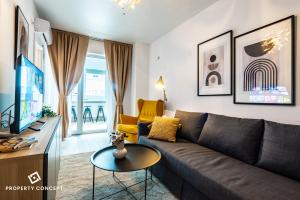 ein Wohnzimmer mit Sofa und Fernseher in der Unterkunft Central Residence Apartment 928 in Vatra Mînăstirii Cotroceni