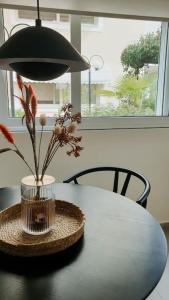 a table with a lamp and a vase with flowers at Terra Apartment in Eretria