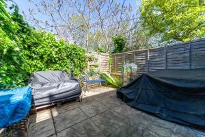 a bed sitting in a backyard next to a fence at Charming Retreat West London - Spacious & Modern in Hanwell