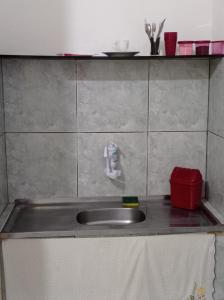 um balcão de cozinha com um lavatório e um recipiente vermelho em Residencial Barbosa 103 em Macaé