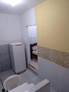 Cette petite chambre dispose d'un réfrigérateur et d'un lit. dans l'établissement Residencial Barbosa 103, à Macaé