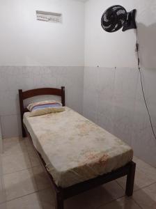 Cama pequeña en habitación con ventilador en Residencial Barbosa 103, en Macaé