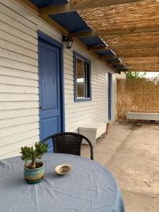 une table et des chaises sur une terrasse avec une porte bleue dans l'établissement SOL DE LA PALMA, à Quillota