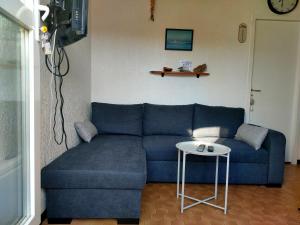 a blue couch in a living room with a table at saint cyprien plage in Saint-Cyprien