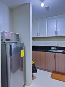 a kitchen with a refrigerator with a microwave on top of it at 1BR and Studio Condo Unit @ 150 Newport near NAIA 3 in Manila