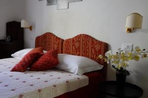 1 dormitorio con 1 cama con almohadas rojas y blancas en B&B Myosotis, en Pisa