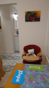 a teddy bear sitting in a chair next to a table at Druskininkų Pasaga in Druskininkai