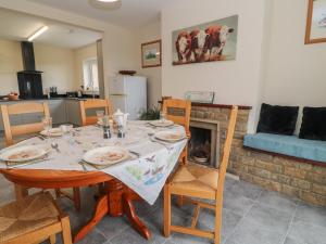 Broadlands Bungalow في شارد: غرفة طعام مع طاولة ومدفأة