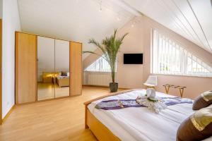1 dormitorio con 1 cama grande y espejo grande en Ferienwohnung Steffen, en Trier