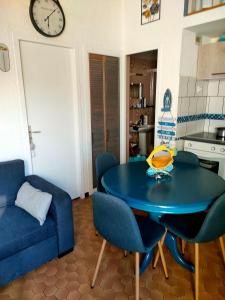 uma sala de estar com uma mesa azul e cadeiras em saint cyprien plage em Saint-Cyprien