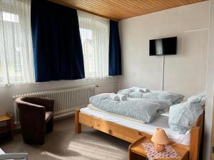 a bedroom with a bed and a tv and a chair at Goldener Loewe in Wunsiedel