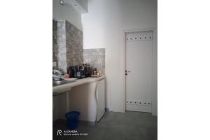 a kitchen with a sink and a white door at Politimis Studio N5 in Amorgos