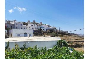 a view of a white building on a hill at Politimis Studio N5 in Amorgos