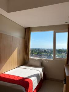 Hotel Brothers Inn Babarsari في Seturan: غرفة نوم بسرير مع نافذة كبيرة