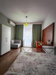 a bedroom with a bed and a desk and a couch at Hostel Charming Double Private Room in Pristina