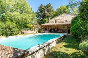 uma piscina num quintal ao lado de uma casa em La Tour em Saint-Rémy-de-Provence