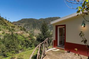 サン・ヴィセンテにあるCasas do Lanço by An Island Apartの山々の景色を望むバルコニー付きの家