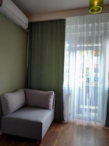 a couch in a room with a large window at Hostel Charming Double Private Room in Pristina