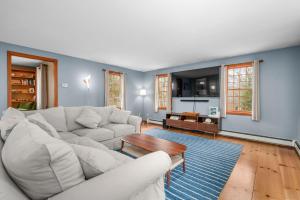 a living room with a white couch and a table at 4 Lookout Point Road Plymouth Z Ocean House in Sandwich