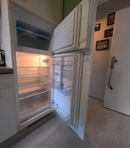 an empty refrigerator with its door open in a kitchen at Waterfriends in Timmendorfer Strand