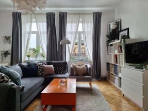 ein Wohnzimmer mit einem Sofa und einem TV in der Unterkunft Beautiful and Spacious Apartment 69m2 for 5 guests next to Florian's Gate in Krakau