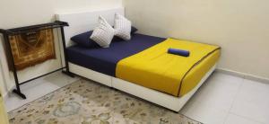 a bedroom with a bed with a yellow and blue blanket at SAFI Homestay Perlis in Arau