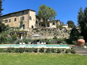 a house with a swimming pool in front of a building at Semifonte Romantica in Petrognano