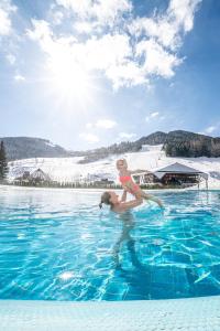 una mujer está parada en un charco de agua en Deluxe Panorama Apartment-Maibrunn-Alm, en Bad Kleinkirchheim