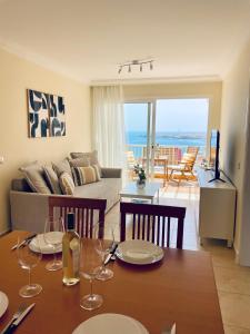 Amazing Ocean View Apartment في بوريس دي أبونا: غرفة معيشة مع طاولة مع كؤوس للنبيذ عليها