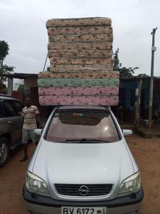 een auto met een stapel dekens erop bij Matelas PEB in Cotonou
