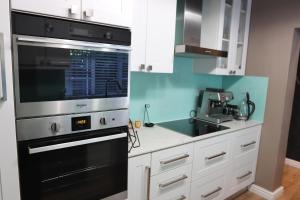 a kitchen with a black oven and a microwave at Scenic two bedroom house with splash pool in Cape Town