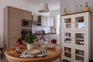 a kitchen with a table with plates and wine glasses at Casa in campagna la Roverella in Francavilla dʼEte +81 photos