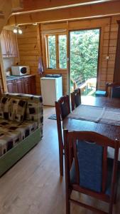 a dining room and kitchen with a table and chairs at Bieszczady Domek Letniskowy in Polańczyk