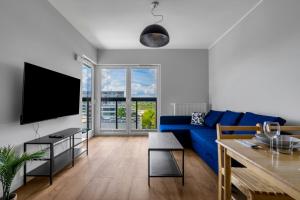 a living room with a blue couch and a tv at Warsaw Bemowo - Parking, Balcony & Workspace - by Rentujemy in Warsaw
