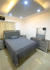 sypialnia z łóżkiem, komodą i lustrem w obiekcie Residencial pancho 6 w mieście La Viva