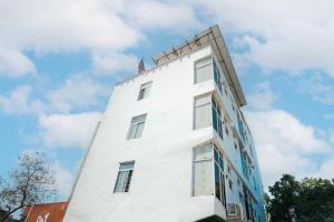 a white building with a clock on it at Hotel The Galaxy in Dabok