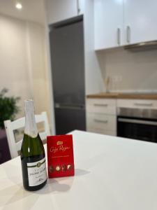 Una botella de vino sentada en una mesa en una cocina en Apartamento Oasis Mediterráneo, en San Vicente del Raspeig