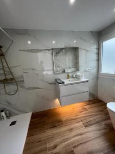 uma casa de banho branca com um lavatório e um WC em Apartamento Oasis Mediterráneo em San Vicente del Raspeig