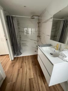 a white bathroom with a sink and a mirror at Apartamento Oasis Mediterráneo in San Vicente del Raspeig