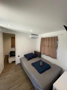 Dormitorio pequeño con cama con almohadas azules en Sona Mobilhome, en Lido di Spina