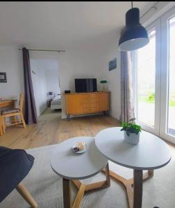 a living room with two tables and a couch at Ferienwohnung Marschblick in Tönning