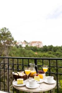 une table avec de la nourriture et des boissons sur un balcon dans l'établissement Pousada Lá Bas, à Campos do Jordão