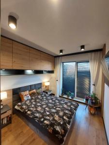 sypialnia z dużym łóżkiem i dużym oknem w obiekcie Apartament Bajkowy w Kołobrzegu