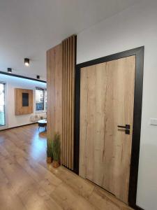 Pokój z dużymi drewnianymi drzwiami w pokoju w obiekcie Apartament Bajkowy w Kołobrzegu