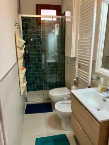 La salle de bains est pourvue de toilettes, d'une douche et d'un lavabo. dans l'établissement Appartamento piano terra centro, à Viareggio